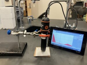 Radiation monitor in action, measuring decay from a source behind an aluminum sheet barrier